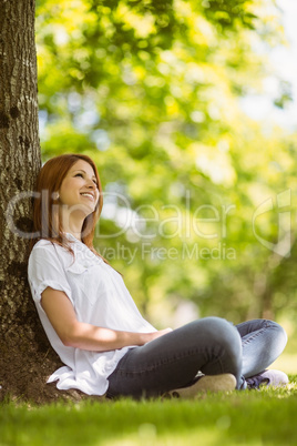 Pretty redhead sitting and smiling in casual clothing