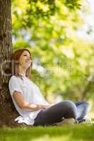 Pretty redhead sitting and smiling in casual clothing