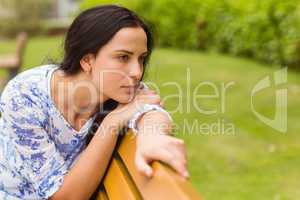 Thoughtful brunette sitting on bench