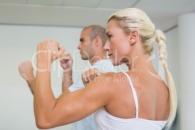 Sporty couple clenching fists at fitness studio