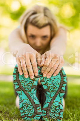 Fit blonde stretching on the grass