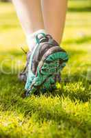 Woman in running shoes stepping on grass