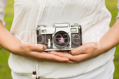 Mid section of woman holding retro camera