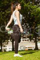 Healthy woman stretching leg in park