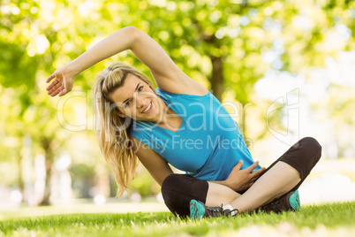 Fit blonde sitting on the grass