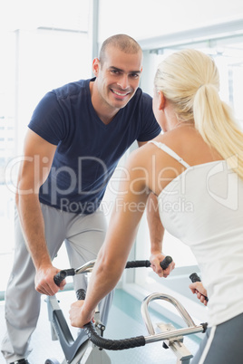 Smiling couple working on exercise bikes at gym