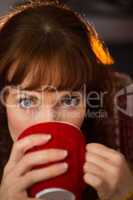 Portrait of redhead drinking hot drink at christmas