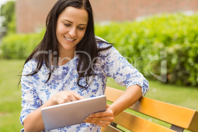 Smiling brunette touching her tablet