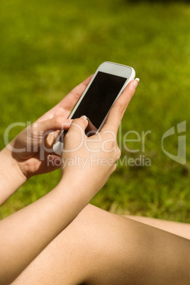 Hands holding smartphone in park