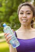 Healthy woman holding water bottle in park