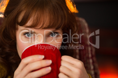 Portrait of beauty redhead drinking hot drink at christmas