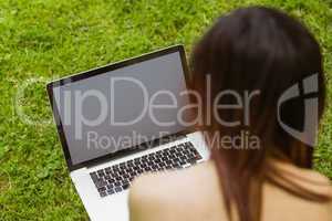 Relaxed woman using laptop in park