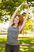 Pretty redhead stretching in the park