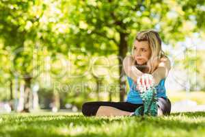Fit blonde stretching on the grass