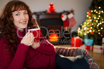 Pretty redhead enjoying hot drink at christmas