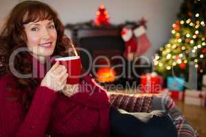 Pretty redhead enjoying hot drink at christmas