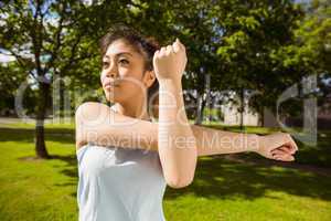 Healthy woman stretching hands in park