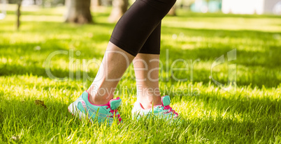 Woman in running shoes stepping on grass