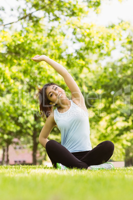 Healthy woman stretching hands in park