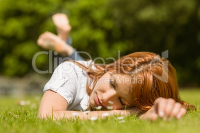 Pretty redhead napping on grass