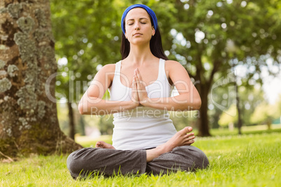 Brunette sitting in lotus pose with hands together