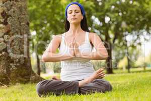 Brunette sitting in lotus pose with hands together
