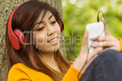 Relaxed woman enjoying music in park