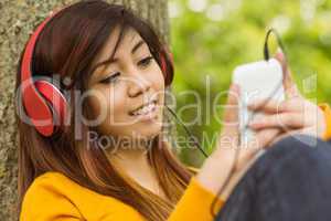 Relaxed woman enjoying music in park