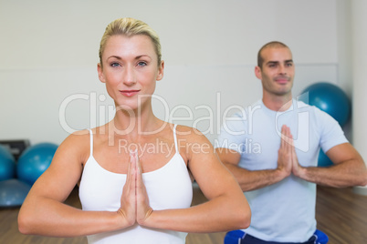 Sporty couple with joined hands at fitness studio