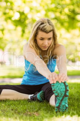 Fit blonde stretching on the grass