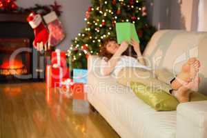 Relaxed redhead reading on the couch at christmas
