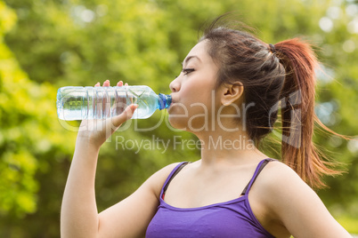 Healthy woman drinking water in park