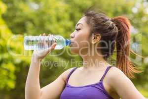Healthy woman drinking water in park