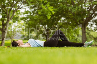 Healthy woman lying on grass in park