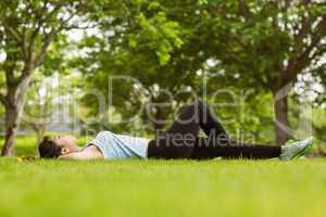 Healthy woman lying on grass in park