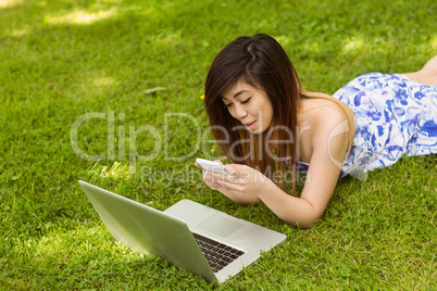 Beautiful woman text messaging in park