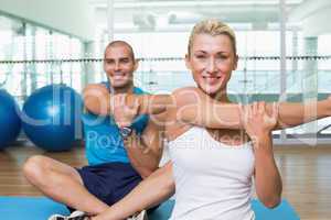 Couple stretching hands in yoga class