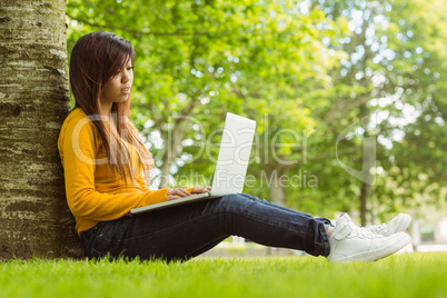 Relaxed young woman using laptop in park