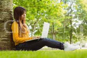 Relaxed young woman using laptop in park