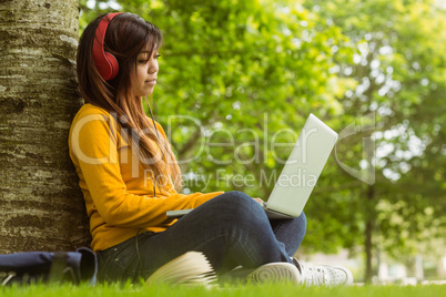 Relaxed young woman using laptop in park