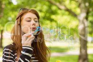 Woman blowing bubbles at park