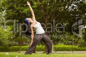 Peaceful brunette doing yoga in the park