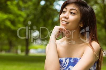 Beautiful woman with hand on chin in park