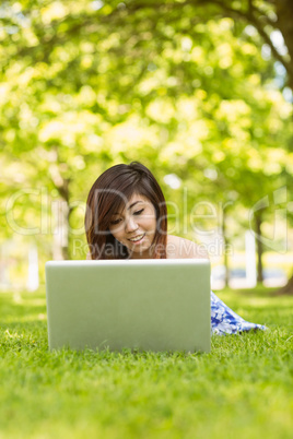 Relaxed woman using laptop in park