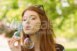 Woman blowing bubbles at park