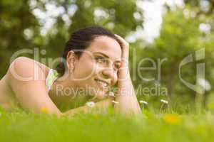Relaxed fit brunette lying on grass