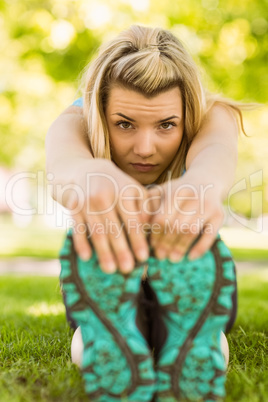 Fit blonde stretching on the grass