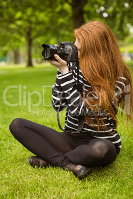 Female photographer sitting on grass