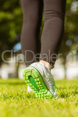 Woman in sports shoes jogging at park