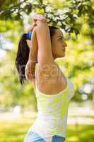 Focused fit brunette stretching in the park